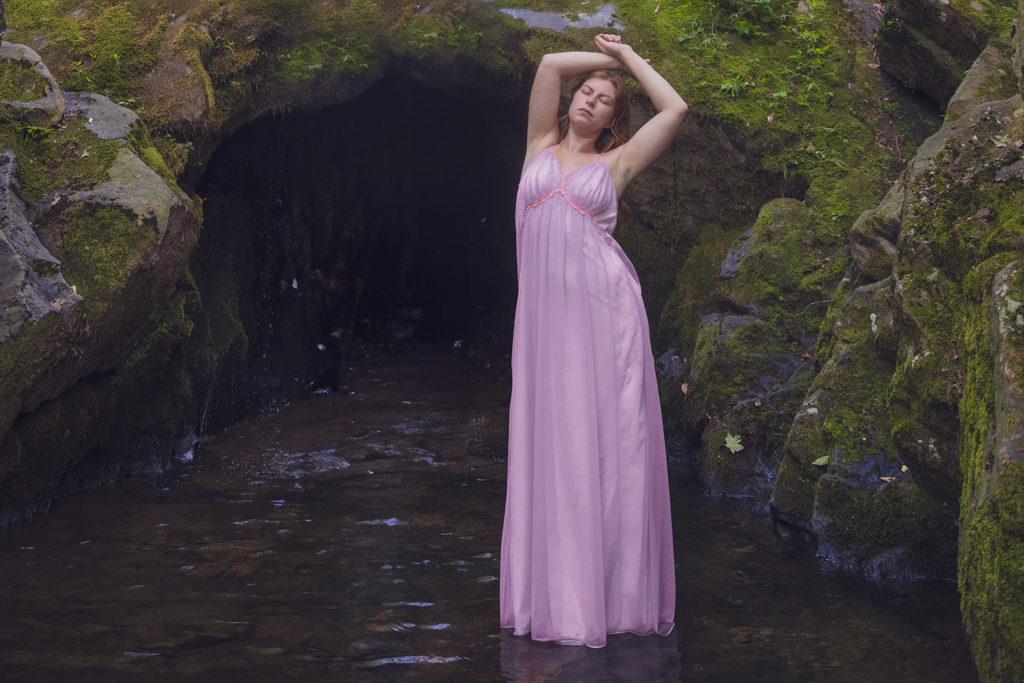 girl in lavender nightgown floating on water at most of cave