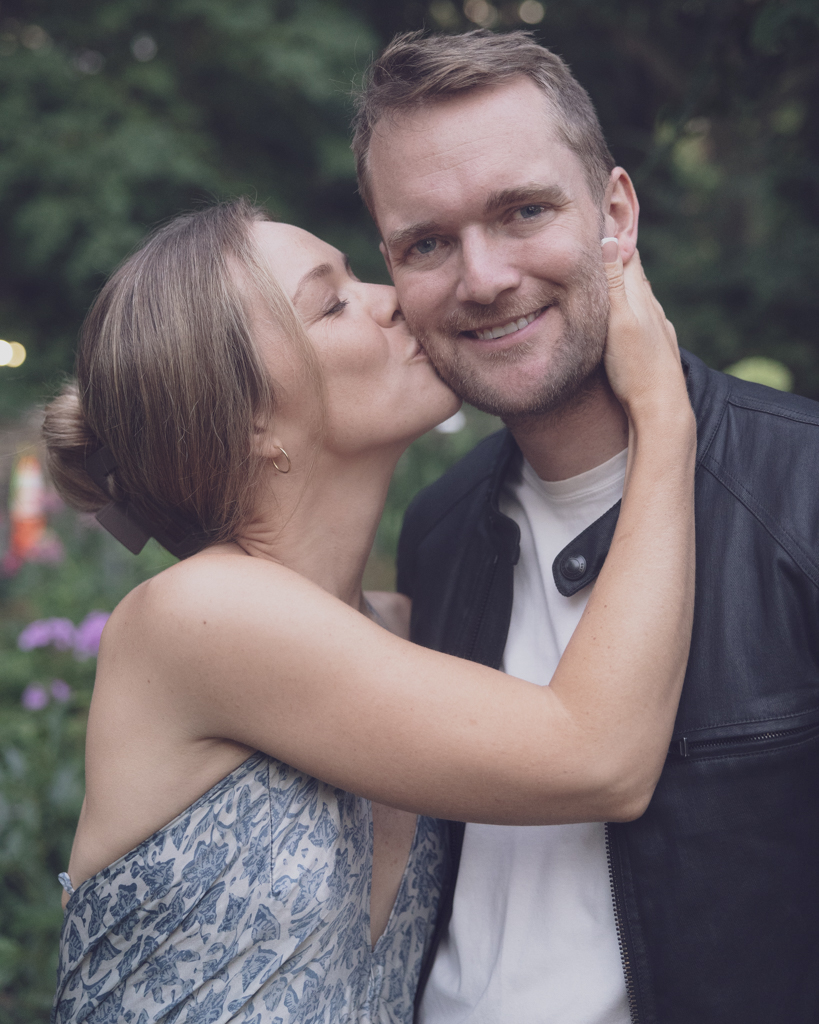 Emily and Liam couple poses in garden NYC Upper West Side Engagement shoot