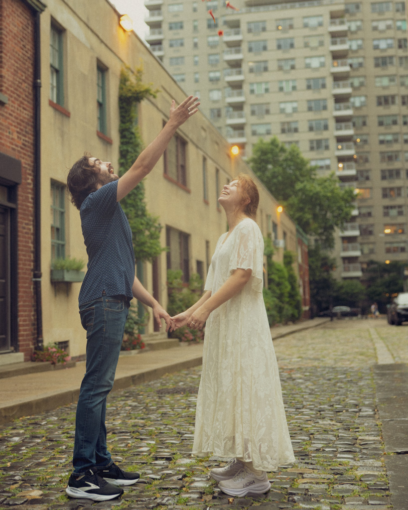 Romantic NYC couple photoshoot of Lucy and Mark dancing on the cobblestone streets of Washington Mews, Manhattan